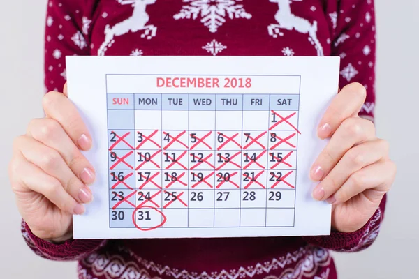 It\'s five days to new year! Cropped close up photo of calendar in woman\'s hands isolated on grey background