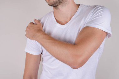 Terapi hastalıklı tedavi konsepti. Üzgün üzgün, mutsuz, omuzlarına dokunan adam gri arka plan fotokopi alanında izole edilmiş.