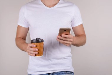Yakışıklı erkeksi erkeksi tabaklanmış tenli çekici insanlar kişi öğrenci içme sıcak içecek gri arka plan üzerinde izole cep kullanarak fotoğrafı yakın kırpılmış