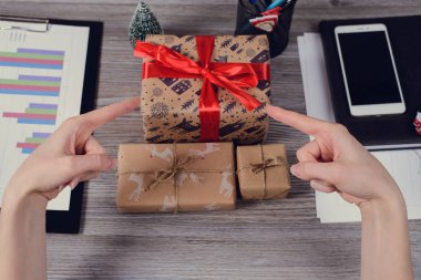 POV yüksek ilk kişi genel gider görüş açısı yakın güzel kırmızı kurdele fotoğrafı kadar yay unwrapped sarılmış kapalı paketi açmak elinde ahşap masa üzerinde kağıt