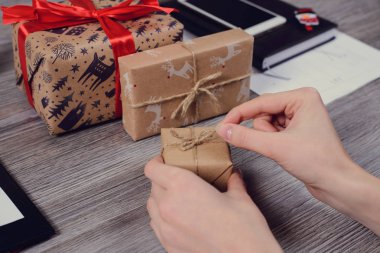 POV yüksek ilk kişi genel gider görüş açısı yakın güzel kırmızı kurdele fotoğrafı kadar yay unwrapped sarılmış kapalı paketi açmak elinde ahşap masa üzerinde kağıt