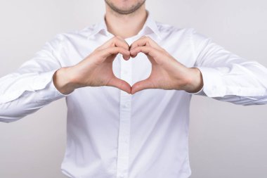 Neşeli yakışıklı güzel memnun pozitif adam iki yarısı izole gri arka plan kalp yapma Kırpılmış closeup fotoğraf