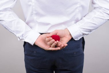 Bedind arka görüş fotoğraf heyecanlı sinirli beyefendi gizleme küçük parlak kırmızı kutusunun arkasına yüzüklü gri arka plan izole