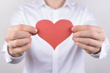İzole göğüs gri arka plan kalbinde neşeli yakışıklı rüya rüya gibi güzel güzel şirin ihale sevindim olumlu gülümseyen adam portresi yakın çekim fotoğraf kırpılmış