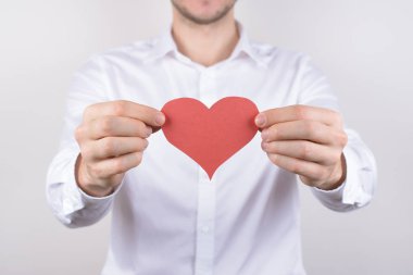 İzole göğüs gri arka plan kalbinde neşeli yakışıklı rüya rüya gibi güzel güzel şirin ihale sevindim olumlu gülümseyen adam portresi yakın çekim fotoğraf kırpılmış