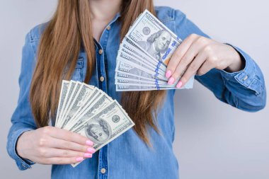Mutlu memnun büyüleyici güzel o onun Bayan elleri giyen Denim rahat gömlek izole gri arka plan para yığınları yığınlar övünme kırpılmış çekim fotoğraf görünümü