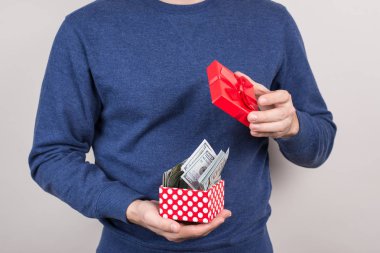 Closeup para izole gri arka plan dolu küçük kırmızı küçük paket açılış memnun başarılı şanslı şans adam fotoğraf kırpılmış