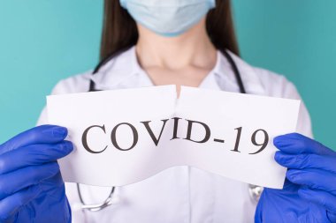 Yeni Coronavirus romanı Ncov konseptin üstesinden geldi. Beyaz önlüklü profesyonel doktorun COVID 19 kağıdını yırtarken çekilmiş yakın plan fotoğrafı.