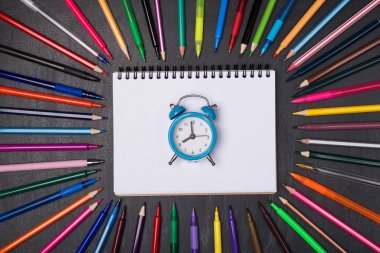 Son teslim tarihi çan konseptinin sonudur. Yukarıdaki görünümde boş defterin üzerinde yatan saatin fotoğrafı. Kalemler ve karatahtaya izole edilmiş kalemlerle çevrili.