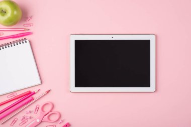 Uzaktan çalışma ve çalışma konsepti. Yukarıdaki resim tablet renkli, boş not defteri ve elmanın fotokopi uzaylı pastel pembe arka planda izole edilmiş fotoğrafı.