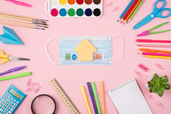 Staying at home concept. Top above overhead view photo of colorful stationery blue mask home letters and succulent isolated on pastel pink background