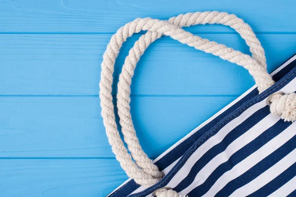 Summer vacation concept. Top above overhead view photo of blue striped bag isolated on blue wooden background