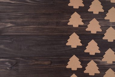 Tepedeki düz tepede noel ağacı şekilli kağıt süslemelerin resmi duruyor. Sağ tarafa yerleştirilmiş, ahşap arka planda izole edilmiş, kopyalanmış.