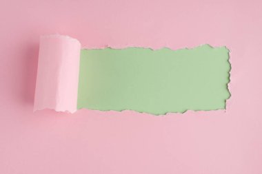 Açık yeşil arkaplan üzerinde kopyalanmış pembe kağıdın yukarıdaki görünüm fotoğrafı