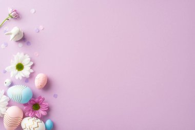 Açık mor bir ortamda yumurtalar, porselen tavşanlar, papatyalar ve konfetilerle yukarıdan görülen şık Paskalya kompozisyonu kişisel mesajlar veya reklamlar için bir yer sunuyor.