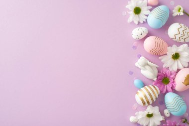 Açık mor bir yüzey üzerinde yumurtalar, seramik tavşanlar, papatyalar ve konfeti ile yukarıdan görülen şık Paskalya düzenlemeleri tatil dilekleri ve reklamlarınız için bir yer sağlıyor.