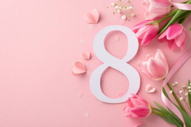 Kadınlar Günü konsepti. 8 Mart tarihinin en üst görüntüsü, tam bir buket lale ve gypôila, bir kurdele ve pastel pembe bir tuval üzerinde kalp hatları, metin için ayrılmış yer.