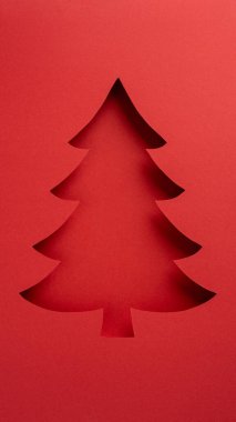 Kırmızı kağıdın üzerinde şenlikli dikey ağaç silueti, bayram tebrikleri ya da ilham için mükemmel.