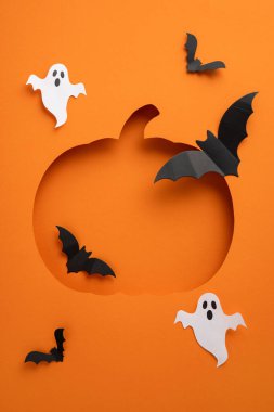 Uçan yarasalar ve turuncu arka planda süzülen hayaletlerle çevrili balkabağı şekilli dikey bir Cadılar Bayramı sahnesi neşeli ve ürkütücü bir tatil atmosferi yaratıyor.