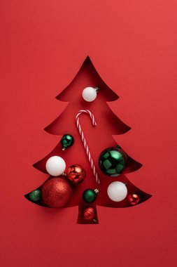 Şenlikli dikey Noel kartı. Süslü ve şeker kamışlı ağaç kesimi.