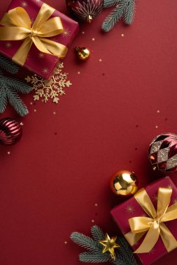 Kutlama kartları ve mevsimsel promosyonlar için mükemmel bir tatil havası yaratan şarap rengi hediyeler, altın kurdeleler, çam dalları ve parlak süslemeler içeren şenlikli dikey sahneler.