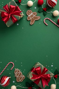 İçinde hediyeler, zencefilli kurabiyeler, baston şekerler ve yeşil arka planda kırmızı kurdeleler bulunan canlı bir tatil sahnesi. Neşeli, sıcak ve kutlama havası Noel ve yeni yıl için mükemmel.