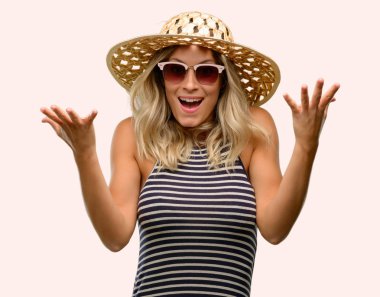 Güneş gözlüğü yaz şapka mutlu ve tezahürat ifade wow jest giyen kullanan genç kadın