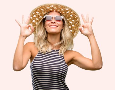 Meditasyon ve gevşeme ifade iki elinle ok işareti jest yapıyor yaz şapka güneş gözlüğü kullanan genç kadın