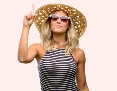 Parmak, bir numara yükselterek yaz şapka güneş gözlüğü kullanan genç kadın