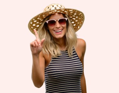 İşaret parmağı ile uzak yan yaz şapka güneş gözlüğü kullanan genç kadın