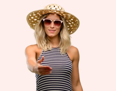 Genç kadın yaz şapka güneş gözlüğü kullanarak el sıkışma poz karşılama, güven ve başarı kavramı ifade, tebrik ellerini tutar