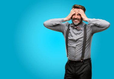 Orta yaş adamla sakal ve papyon stresli tutmak ellerini kafasına, panik içinde dehşete bağırarak