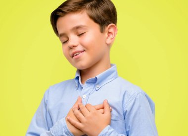 Sarı arka plan üzerinde sevgi ve sağlık kavramı ifade yakışıklı yürümeye başlayan çocuk kalp, elleriyle yeşil gözlü