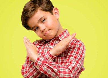 Hayır, güvenlik, savunma veya kısıtlama sarı arka plan üzerinde ifade yeşil gözlü yakışıklı yürümeye başlayan çocuk dur işareti eller, geçiş yapma kötü tutum ile rahatsız