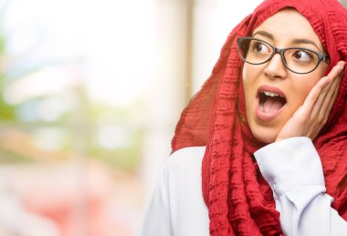 Çok mutlu ve kendinden emin bir büyük gülümseme sürpriz parmak gösterilen hijab giyen genç Arap kadın