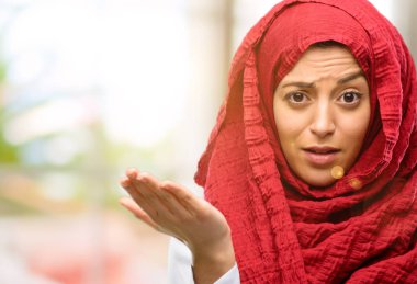 Hijab giyen genç Arap kadın rahatsız ve kızgın negatif duygu ifade, birisi ile rahatsız