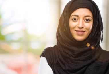 Kendinden emin ve mutlu bir büyük doğal gülümseme gülmek ile çapraz kollu hijab giyen genç Arap kadın