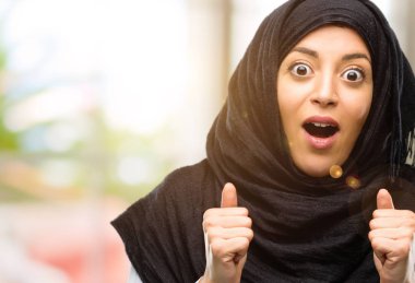 Mutlu ve ifade wow jest tezahürat hijab giyen genç Arap kadın