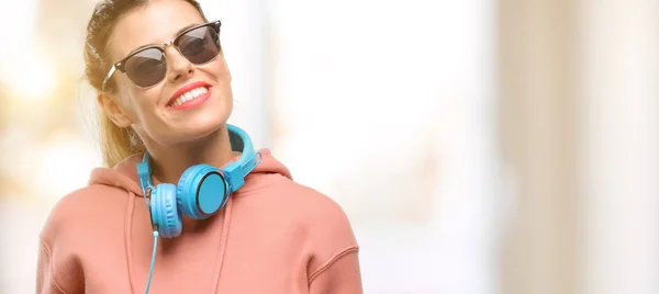 Młoda Kobieta Słuchawki Okulary Przeciwsłoneczne Szczęśliwy Zaskoczony Doping Wyrażając Gest — Zdjęcie stockowe