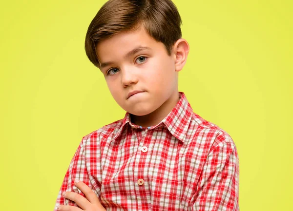 Yeşil gözleri, gergin ve korkmuş ısırma dudaklı sabırsız ifade, sarı arka plan üzerinde dalgın ile kamera seyir yakışıklı yürümeye başlayan çocuk