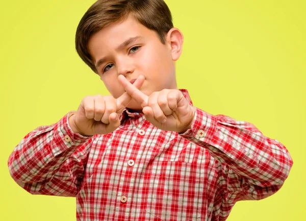 Yeşil gözlü yakışıklı yürümeye başlayan çocuk güvenlik, savunma veya kısıtlama, belki üzerinde sarı arka plana iterek ifade eliyle dur işareti yapma, Hayır, kötü tutum ile rahatsız