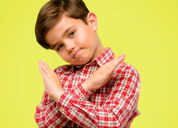 Hayır, güvenlik, savunma veya kısıtlama sarı arka plan üzerinde ifade yeşil gözlü yakışıklı yürümeye başlayan çocuk dur işareti eller, geçiş yapma kötü tutum ile rahatsız