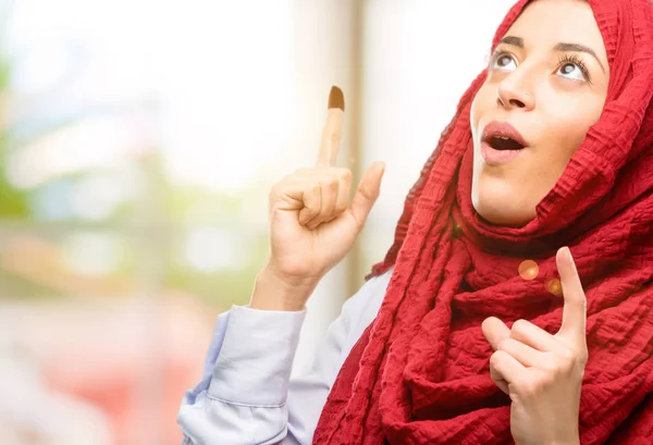 Mutlu ve yukarı dönük ifade wow jest tezahürat hijab giyen genç Arap kadın