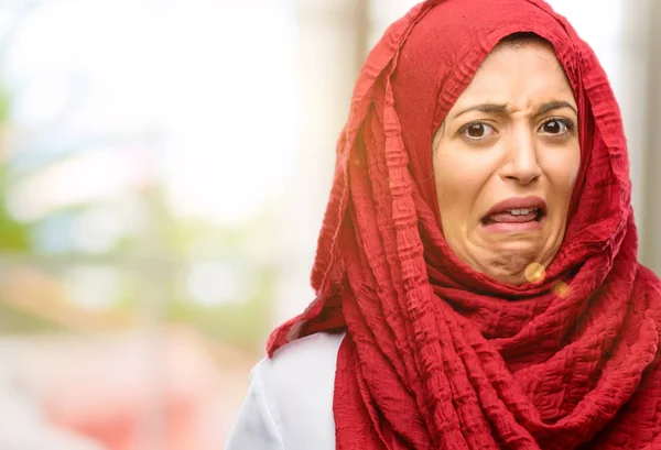 Dilini çıkarmış tiksinti hissi hijab giyen genç Arap kadın