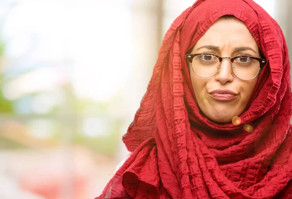 Hijab giyen genç Arap kadın rahatsız ve kızgın negatif duygu ifade, birisi ile rahatsız