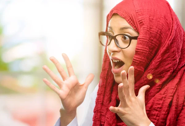 Genç Arap kadın giyiyor hijab stresli tutmak ellerinde kafa, panik, korku içinde bağırarak