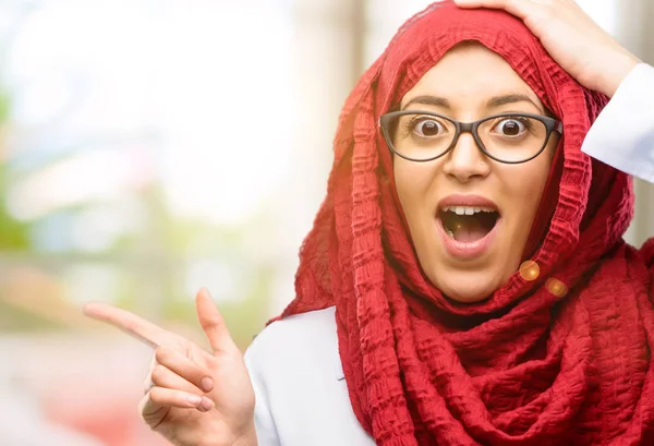 Uzak yan parmağıyla işaret hijab giyen genç Arap kadın