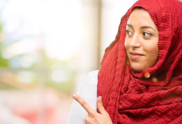 Jovem Árabe Mulher Vestindo Hijab Apontando Para Lado Com Dedo — Fotografia de Stock
