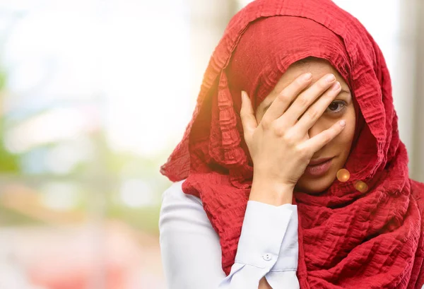 Hijab stresli tutma eller baş, yorgun ve sinirli giyen genç Arap kadın