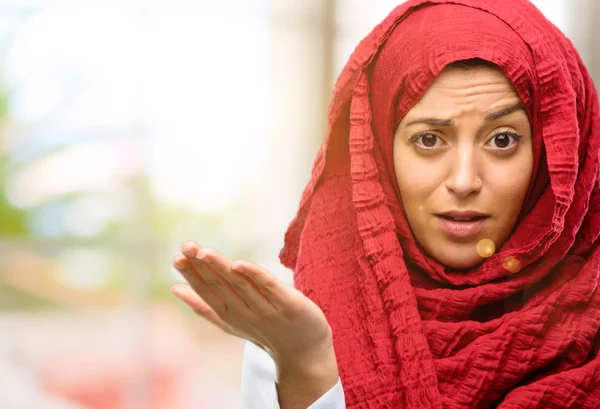 Hijab giyen genç Arap kadın rahatsız ve kızgın negatif duygu ifade, birisi ile rahatsız